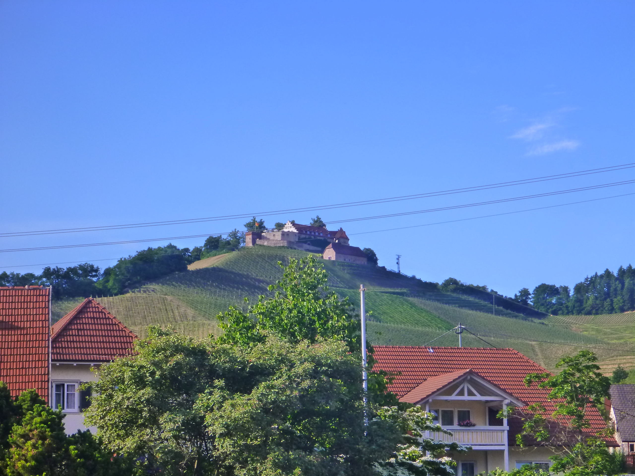 Gebäude auf einem Hügel mit blauem Himmel