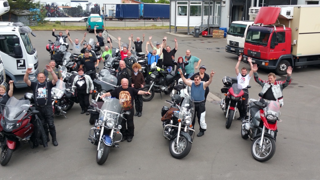 Alle Teilnehmer der Gilde Biker-Tour samt Motorrädern mit den Händen in der Luft
