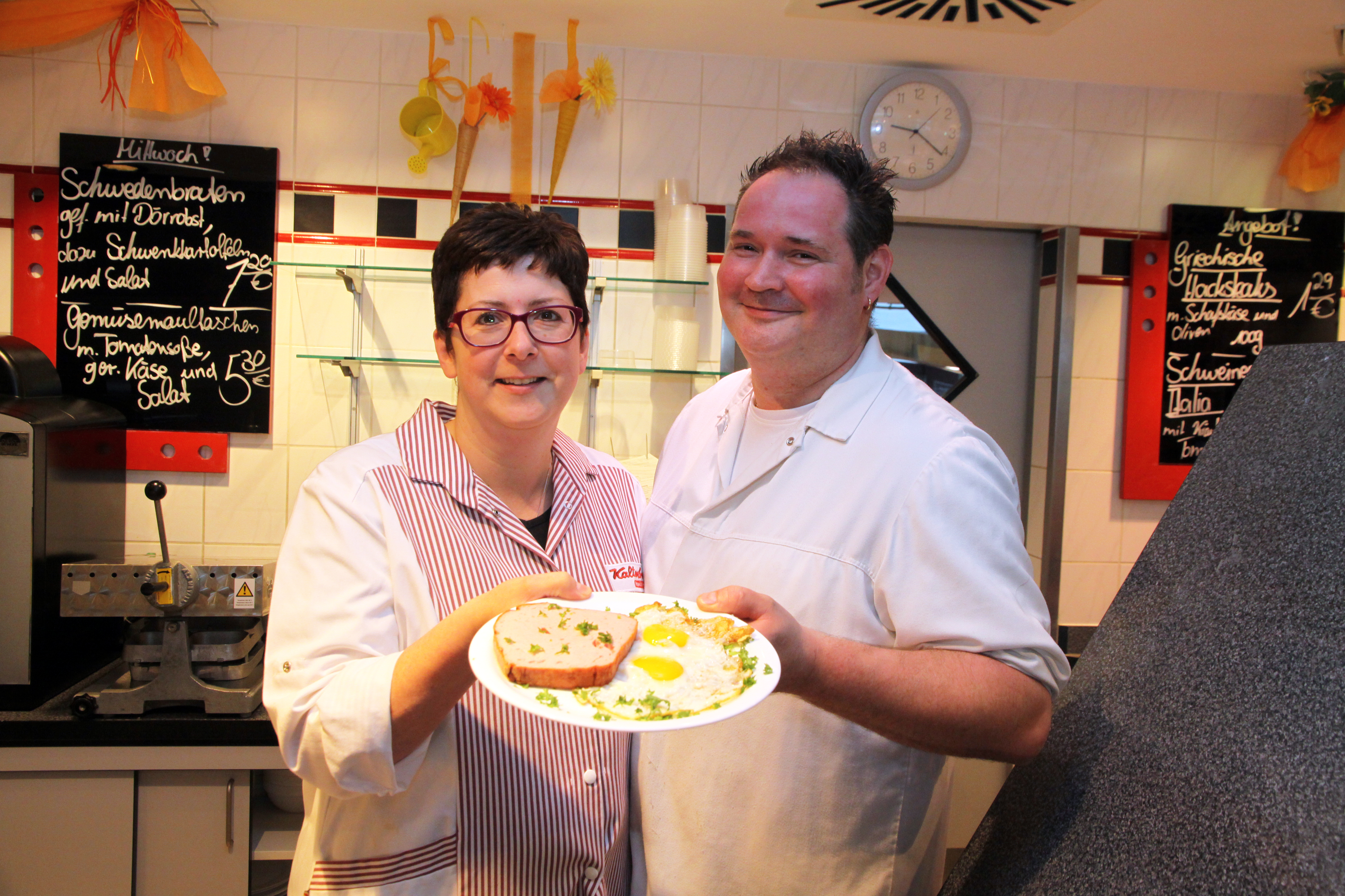 Mitarbeiter der Metzgerei Kaltenborn aus Worms präsentieren einen Teller mit Fleischkäse und Spiegelei