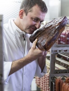 Inhaber der Metzgerei Kienhöfer riecht am getrockneten Fleischzuschnitt