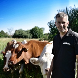 Frank Neumaier vor mehreren Kühen auf der Weide